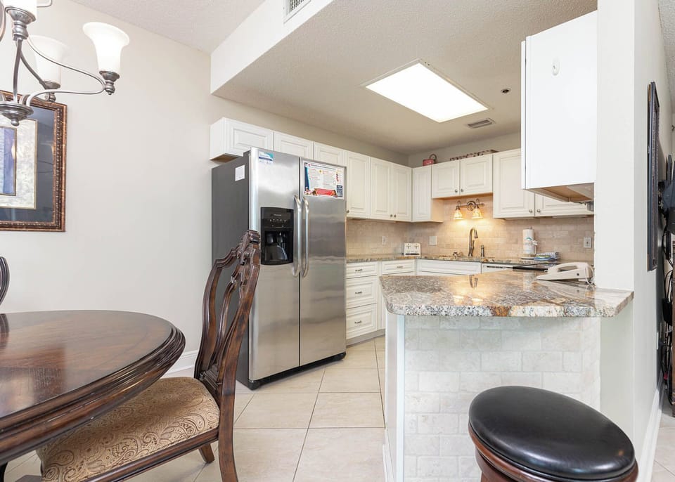 Gather around the elegant dining table while enjoying the inviting kitchen with granite countertops and white cabinetry