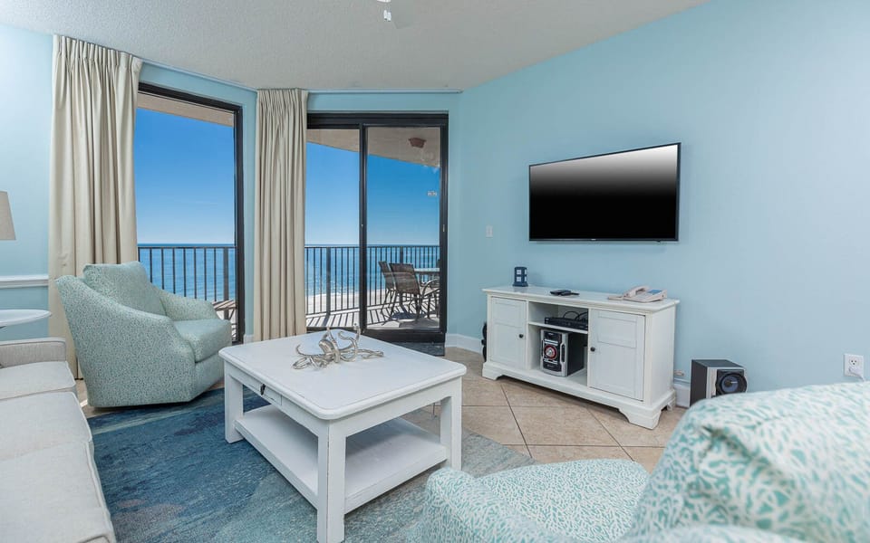 Relax in the inviting living area, featuring a sofa with queen sleeper and a large TV, with stunning views just outside
