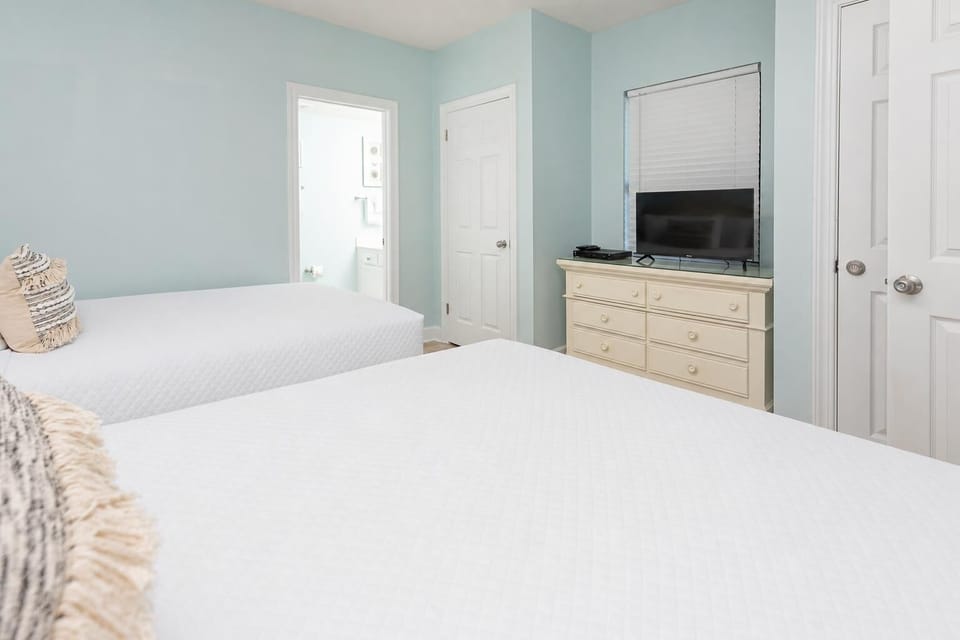 Rest in this inviting guest room with two queen beds, soft linens, a TV, and easy access to the adjoining bathroom