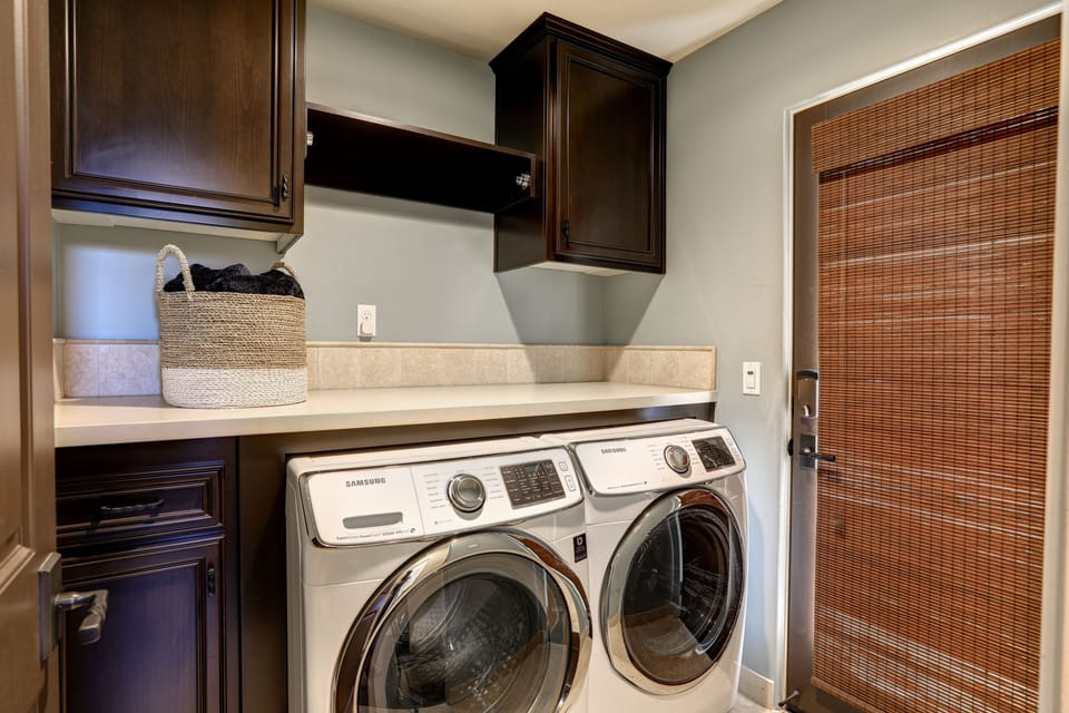 Laundry center includes a full-size washer and dryer, located on the second level near the second bedroom. Roof deck access is also available through the laundry room.