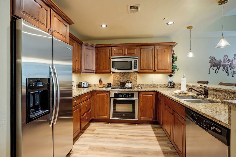 Step into your gourmet kitchen with warm wood cabinets, granite counters, and premium stainless appliances—perfect for creating memorable meals.