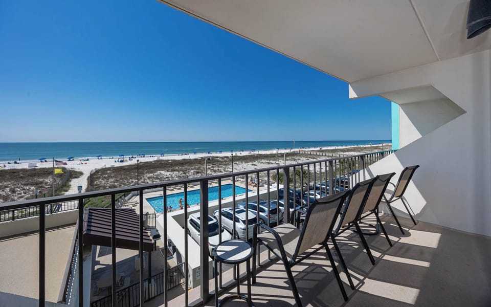 Enjoy stunning beachfront views from the balcony with comfortable seating, perfect for relaxation and unwinding