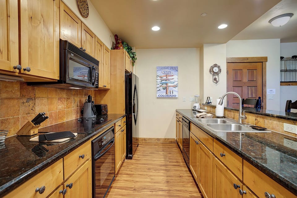 Your fully equipped kitchen features granite countertops, stainless steel appliances, and warm wood cabinetry—perfect for preparing meals during your mountain getaway.