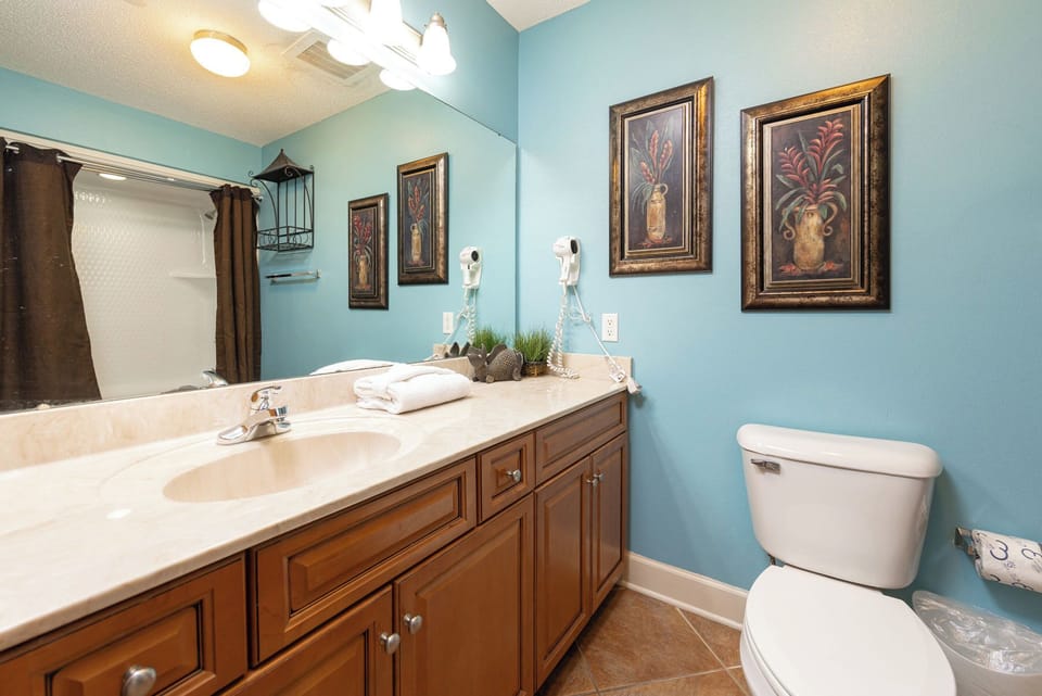 Experience the vibrant decor and spacious vanity as you prepare for your beach adventures in this lovely guest bath