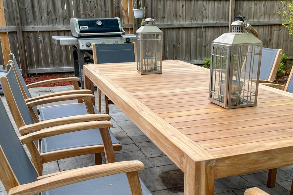The backyard of the home features a paved patio, propane BBQ grill and dining table and chairs