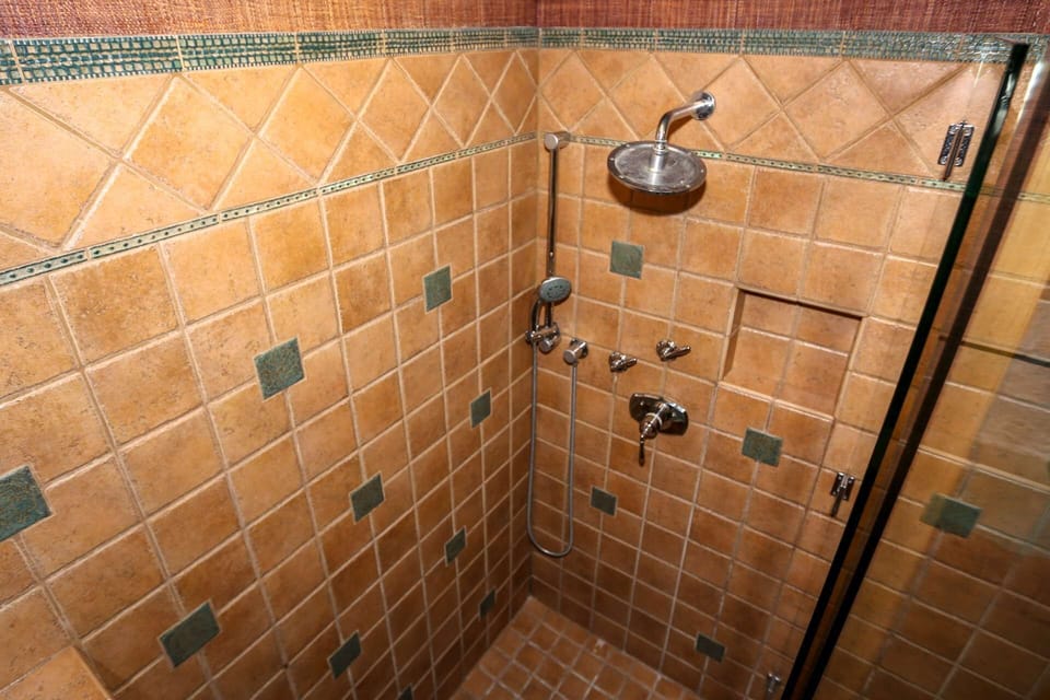 The tiled, walk-in shower in the primary en suite bathroom features two separate showerheads.