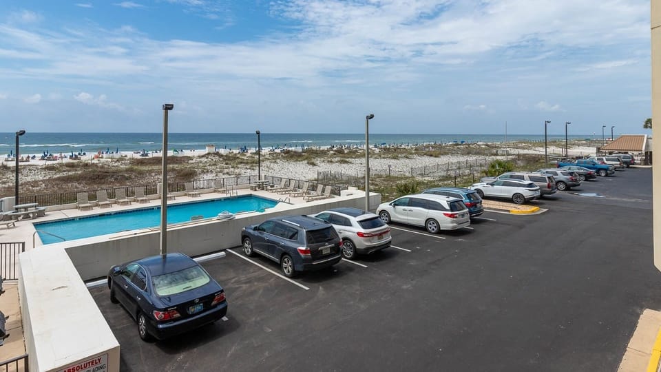 Enjoy a refreshing view of the beachfront and pool area from this inviting outdoor space, perfect for relaxation