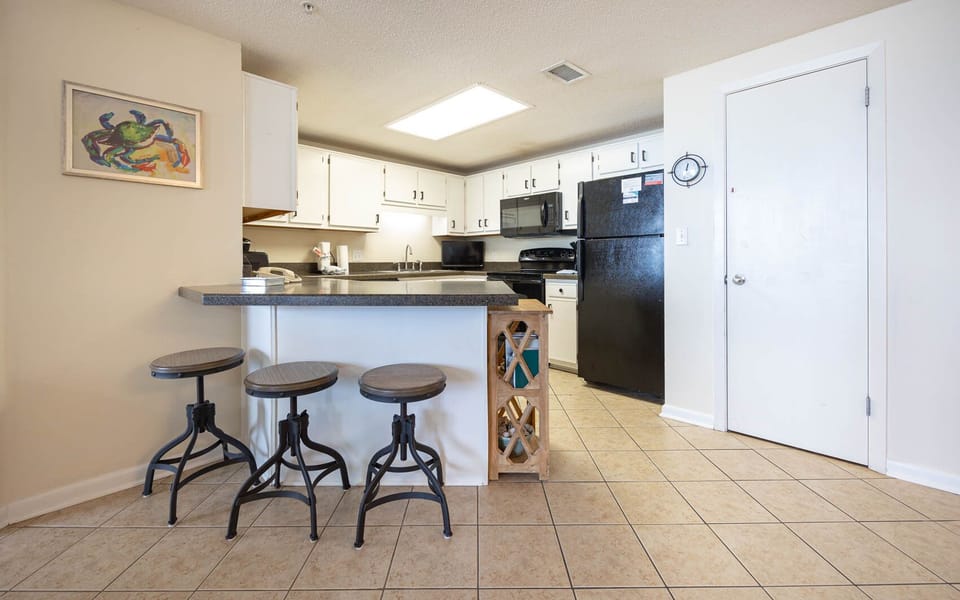 Gather around the kitchen bar with stylish stools, perfect for casual meals and conversation in this inviting space