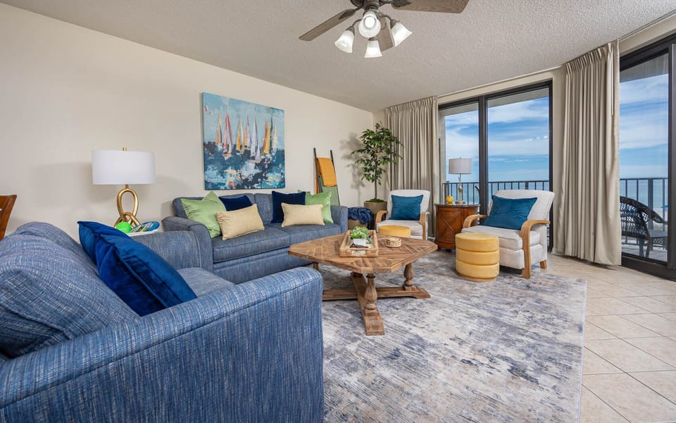 Relax in the inviting living area, featuring comfortable seating, sofa with queen sleeper, and beachfront balcony views