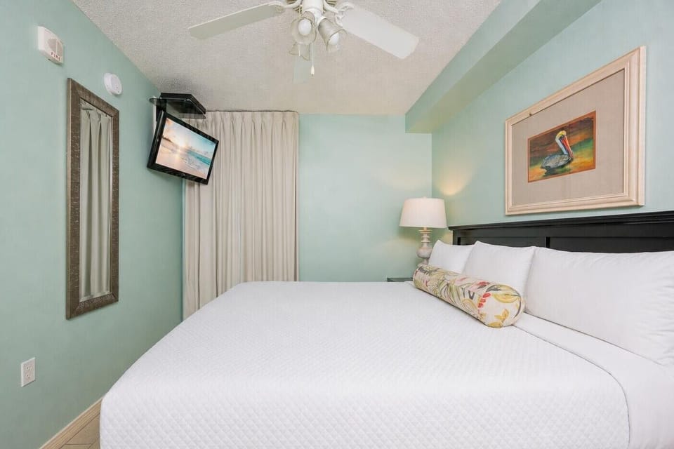 Fluffy pillows invite you to relax in the king suite for a calm movie night after a fun day at the beach