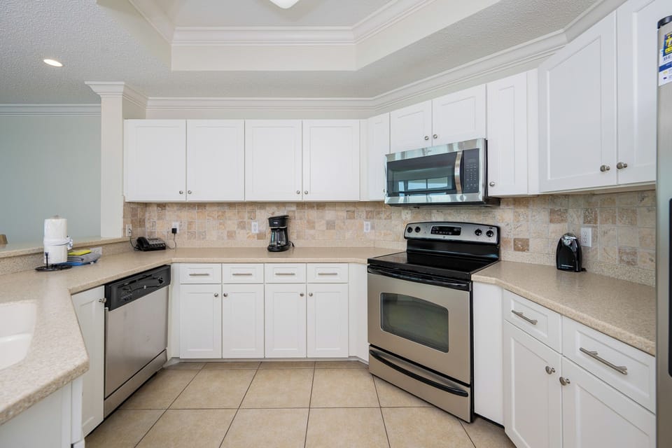 Prepare meals in this kitchen with sleek cabinetry, stainless appliances, and stylish backsplash