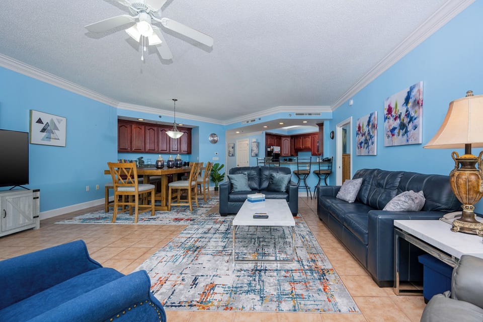 Inviting living area featuring cozy seating, a dining table, and vibrant blue walls for a relaxing retreat