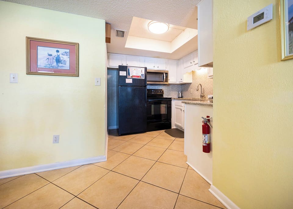 This kitchen features sleek black appliances, granite countertops, and a cozy atmosphere perfect for meal preparation