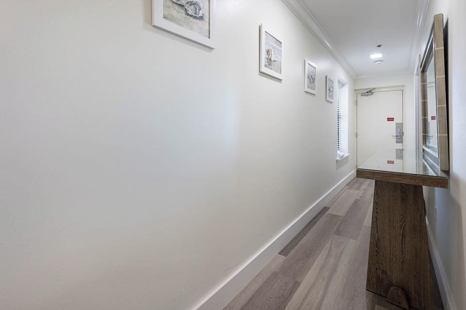 Step into the welcoming hallway adorned with coastal artwork and a stylish console table