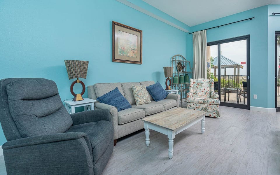 Relax in the inviting living area featuring a sofa with queen sleeper, vibrant decor, and easy access to the outdoor patio