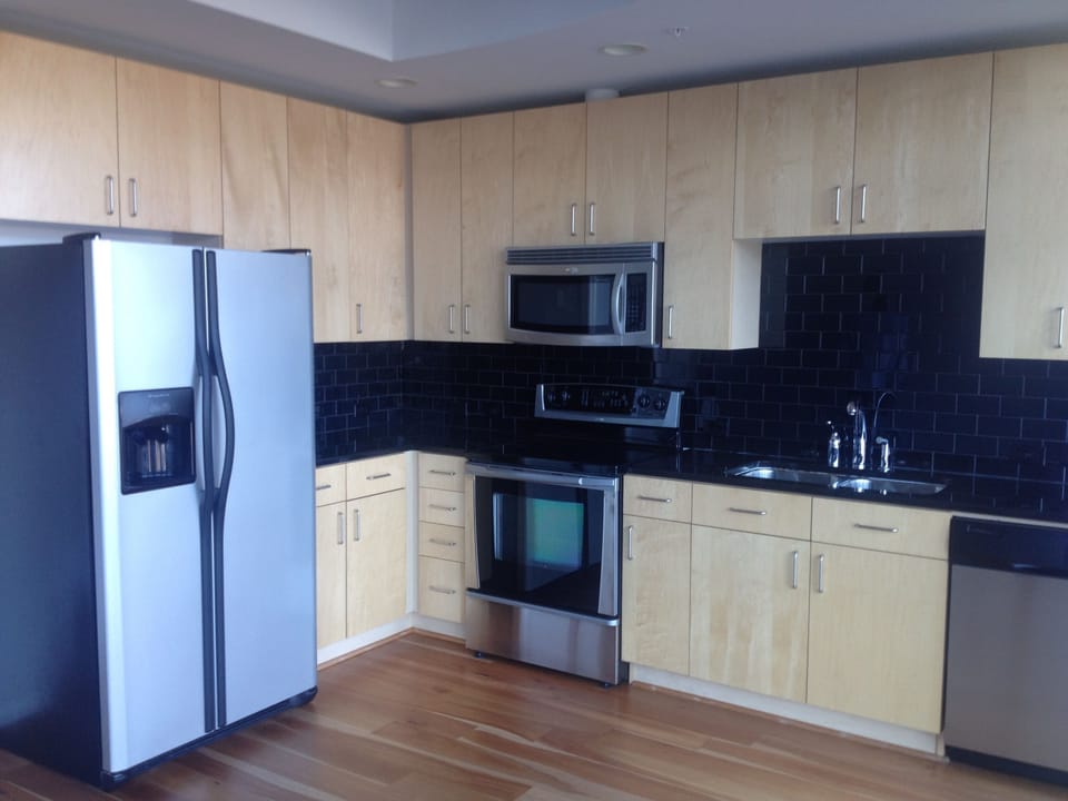 Fully equipped kitchen with granite countertop and tile backsplash.