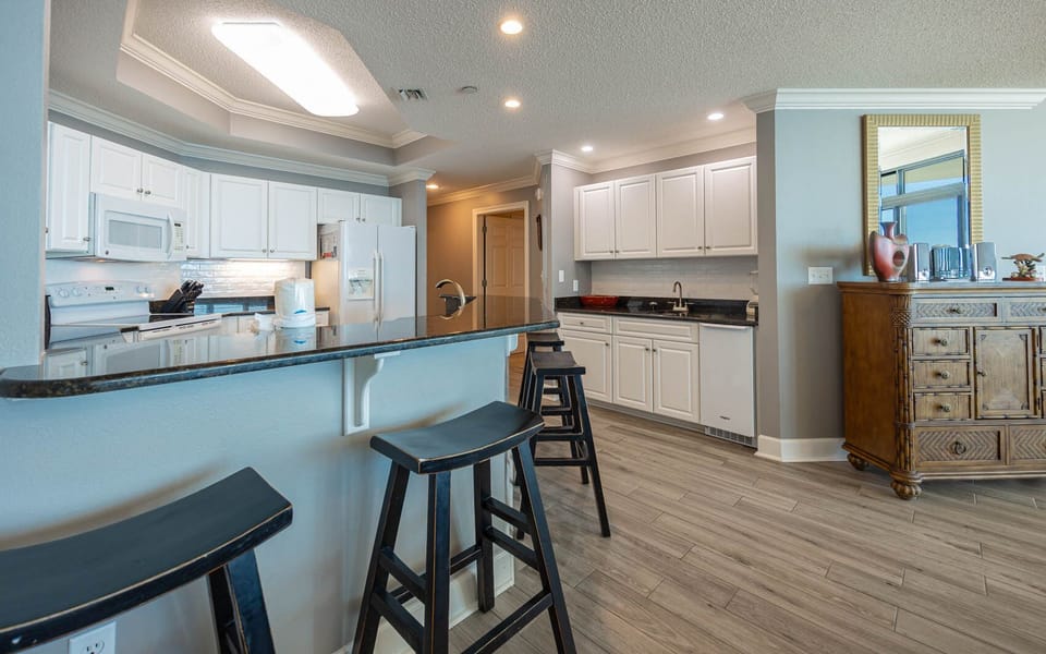 Savor your morning coffee at the sleek breakfast bar, surrounded by inviting coastal decor and natural light