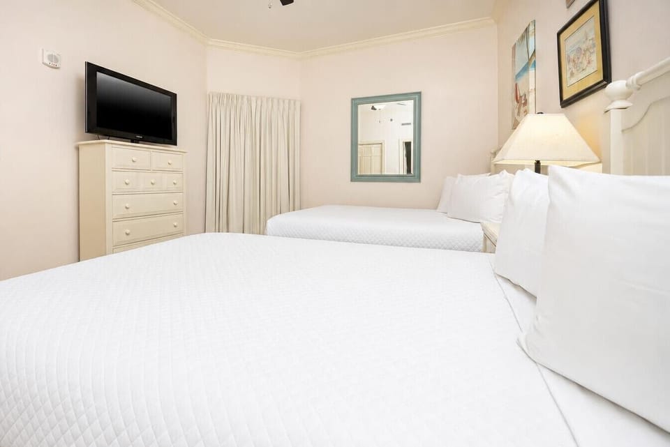 Unwind in this guest room, featuring two double beds and a cozy ambiance for family adventures at the beach