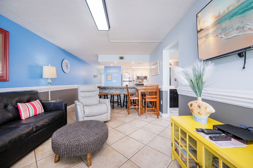 Unwind in the cozy living space, catching up on your favorite shows while enjoying the inviting coastal decor