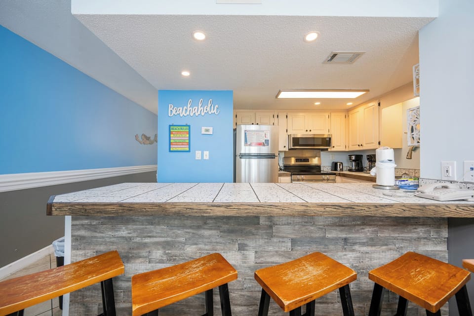 Gather around the inviting bar stools to enjoy memories and share laughter in this cheerful kitchen space