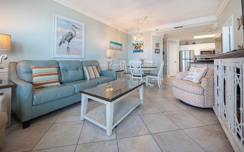 Relax in the airy living space, featuring a comfortable sofa, stylish decor, and a dining area for shared meals