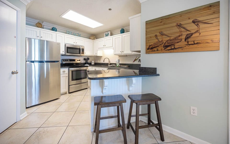 Gather around the kitchen bar with seating, where you can prepare meals and enjoy beach decor
