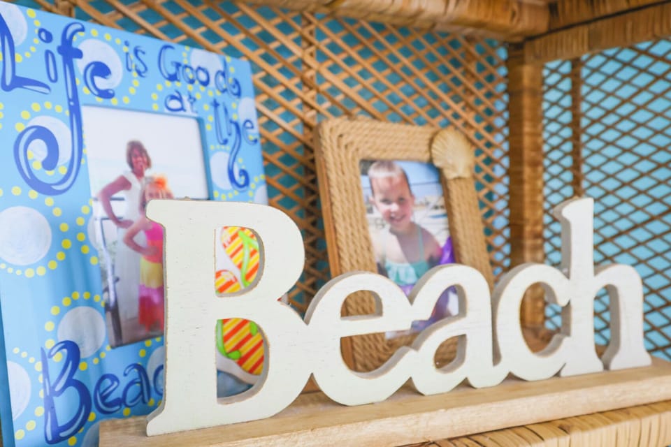 This vibrant decor features a playful "Beach" sign alongside cheerful framed photos, creating a welcoming atmosphere