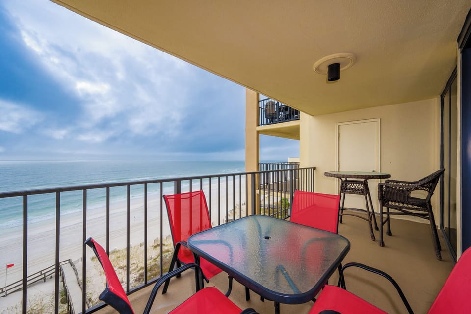 Enjoy the vibrant red seating on the balcony while taking in the breathtaking beach view
