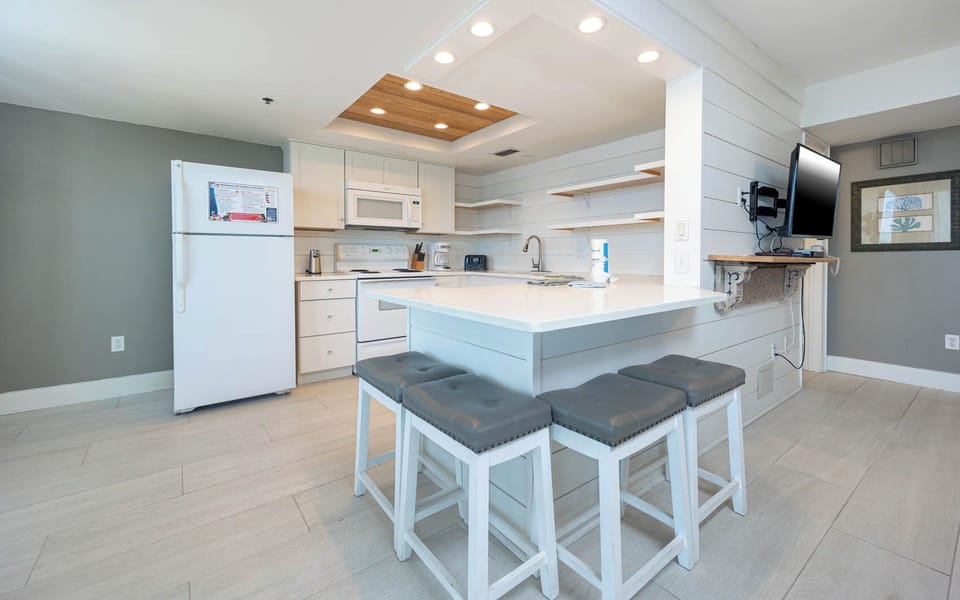 Open kitchen desing featuring sleek cabinetry, appliances, and stylish bar seating for casual dining