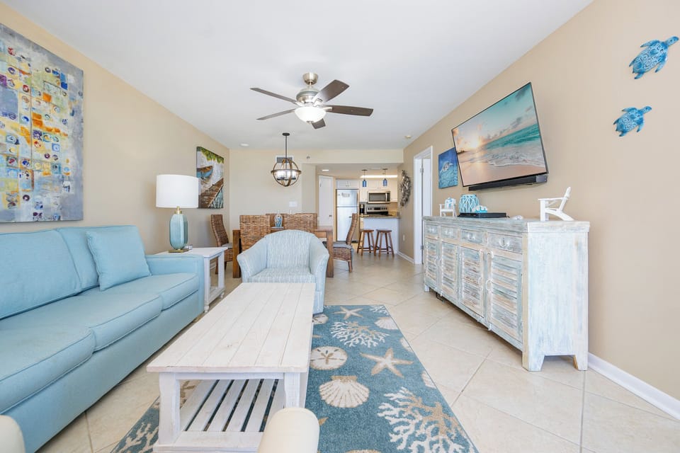 Sink into cushioned blues as you unwind in the living room while a coastal scene plays on the TV wall