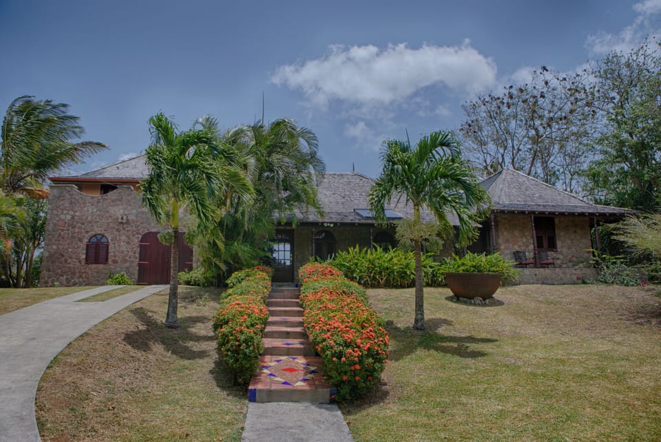 The front entrance is a vibrant walkway accentuated with trees, flowers.