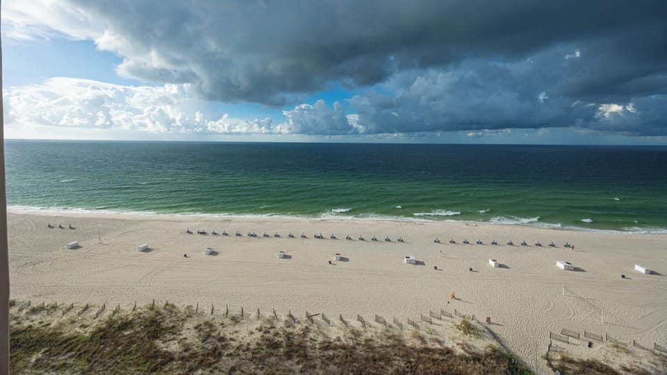 Gaze at the tranquil waters and lounge chairs lining the shore, perfect for a relaxing day by the beach