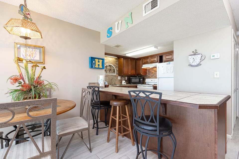 This inviting kitchen features rich wood cabinetry, a breakfast bar, and a cozy dining area perfect for meals together