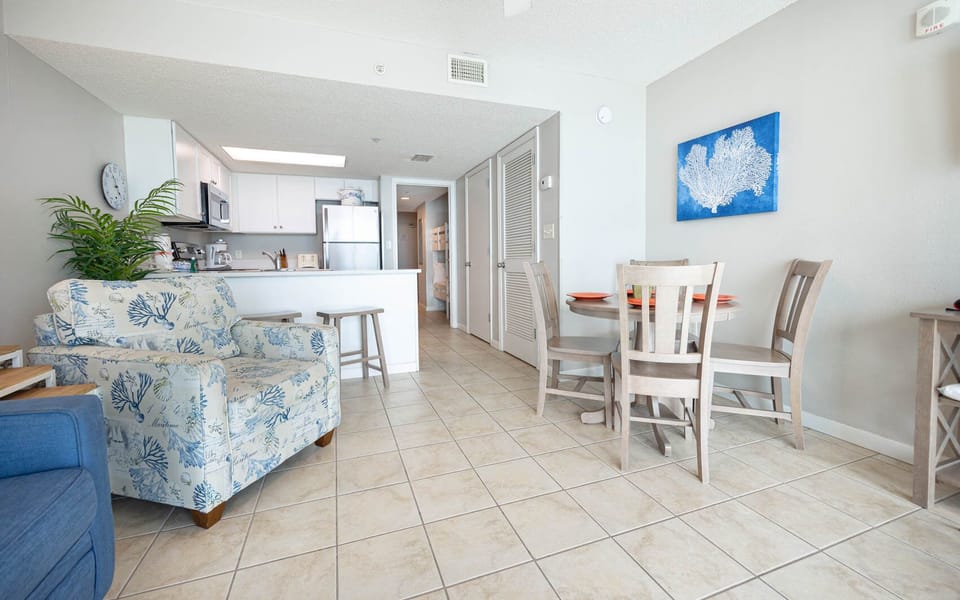 Relax in the inviting living area with comfortable seating, a dining table, and a bright kitchen just steps away