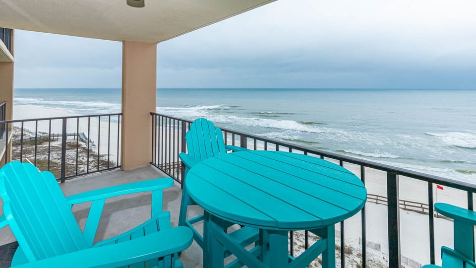 Relax on the eighth floor balcony with coastal furniture while enjoying the serene beach view and gentle waves