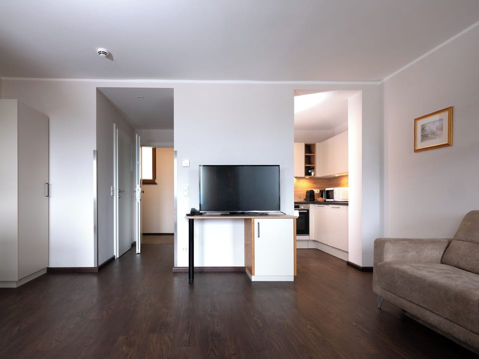 Delux Suite with balcony | Living area | Flat-screen TV, heated floors