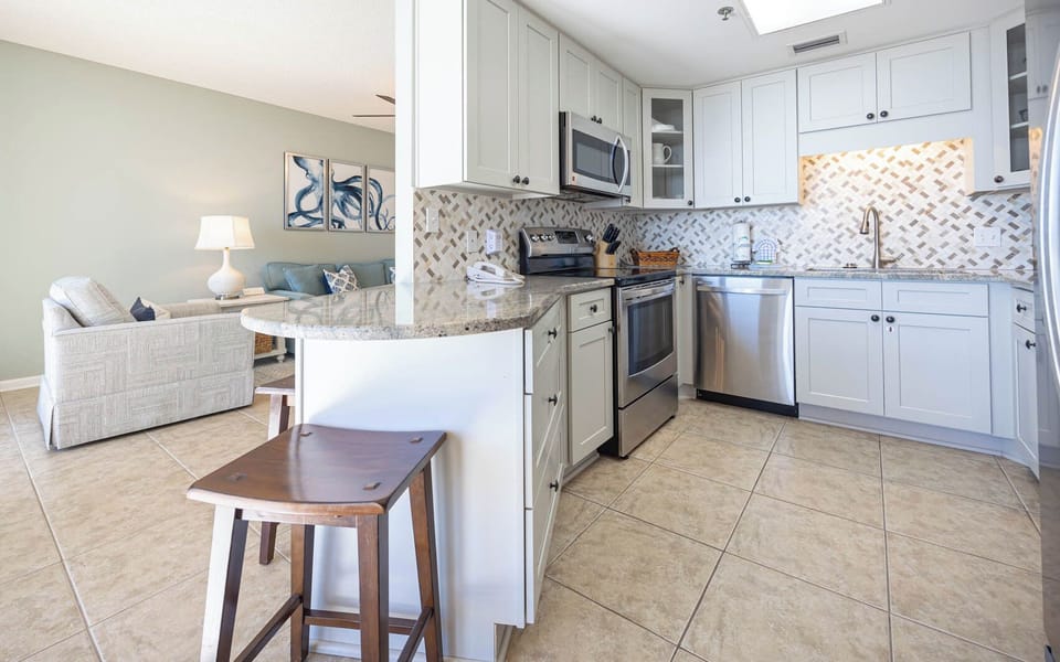 This inviting kitchen features modern stainless appliances and a breakfast bar, perfect for enjoying meals with a view
