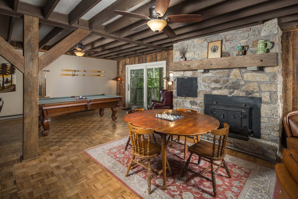 The lower-level game room features a wood-burning fireplace, pool table, and gathering space