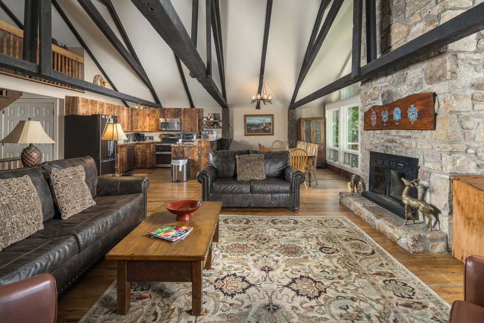 The open living area offers comfortable seating, a wood-burning fireplace, and beautiful mountain views