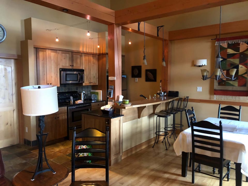 Beautiful kitchen and dining area looks out to mountains.
