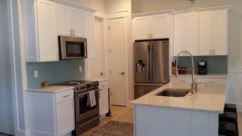 Gourmet kitchen with island and stainless steel appliances + seating for 3