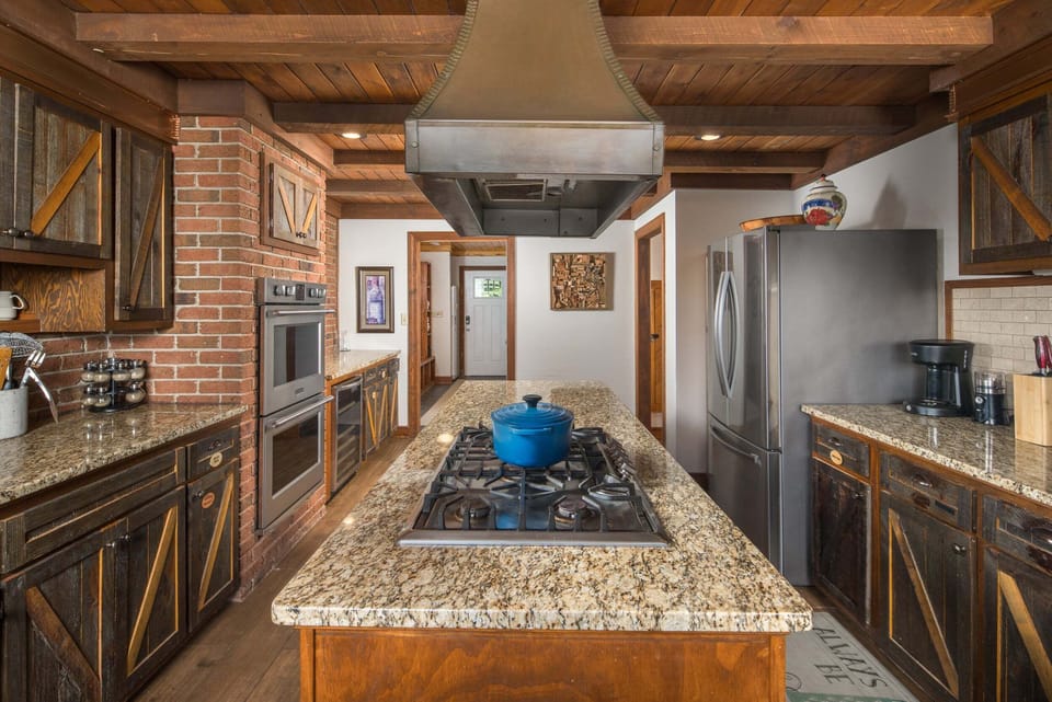 Gourmet chef's kitchen featuring a large island with cooktop, custom cabinetry, and ample workspace