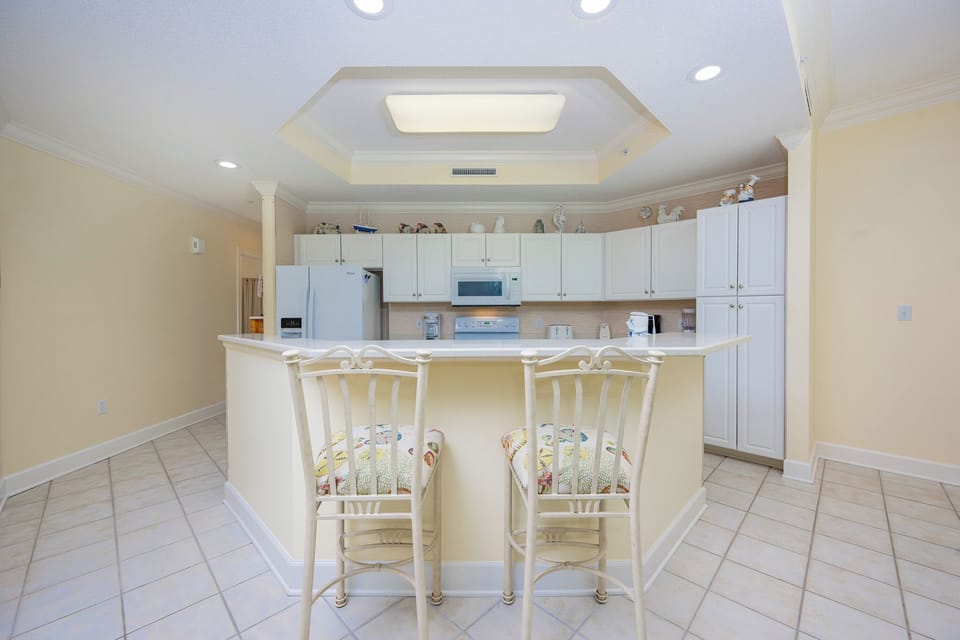 Enjoy casual conversations at the charming counter seating while sipping your favorite beverage in the inviting kitchen