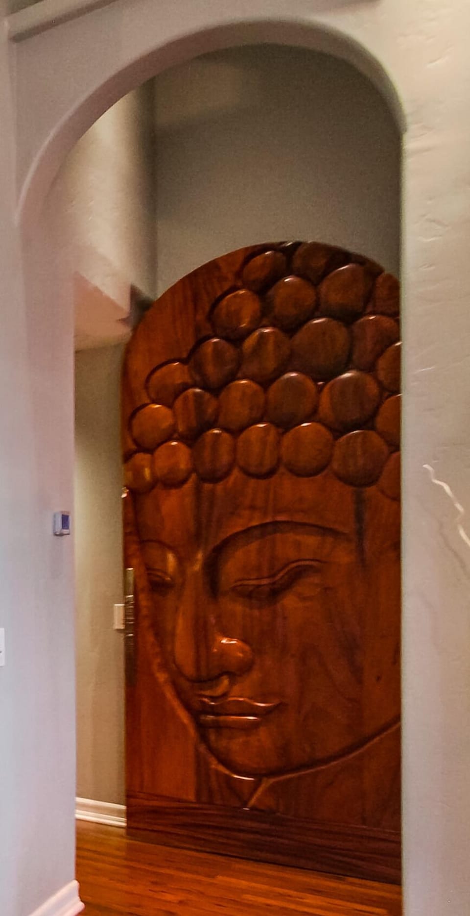 Stunning wooden carved buddha door leads to the master suite