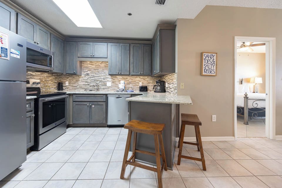 Enjoy preparing meals in this stylish kitchen with stainless appliances, sleek cabinets, and a cozy breakfast bar