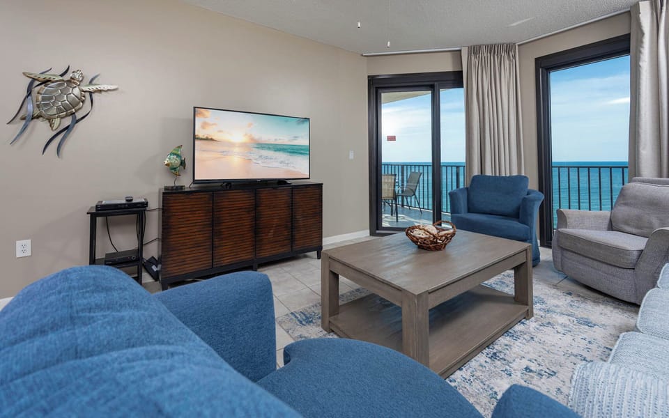 Comfortable living area, featuring a large TV, stylish decor, and beachfront balcony access