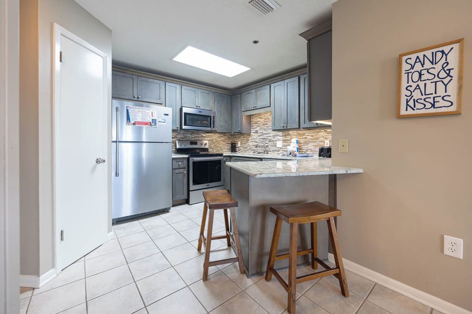 Cook and gather in this inviting kitchen, featuring sleek cabinets, granite counters, and a charming breakfast bar
