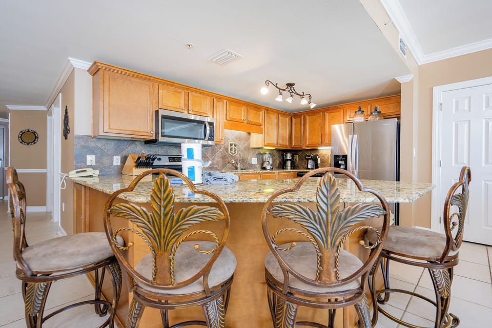 Warmed by under-cabinet lighting, the kitchen invites you to prepare fresh meals and gather at the breakfast bar