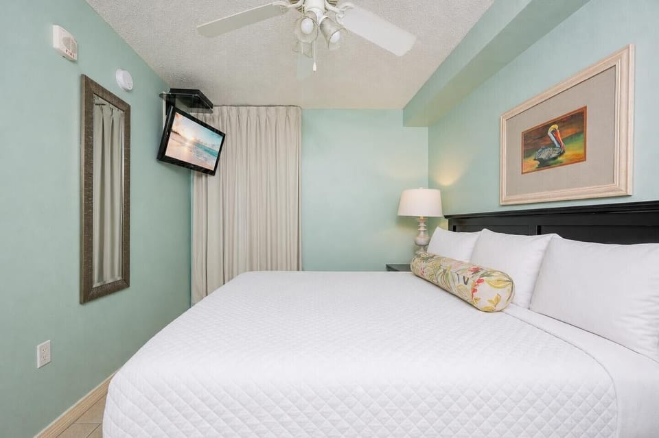 Fluffy pillows invite you to relax in the king suite for a calm movie night after a fun day at the beach