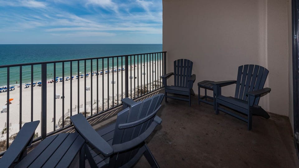 Relax in comfortable chairs on the balcony while enjoying views of the beach and gentle waves below